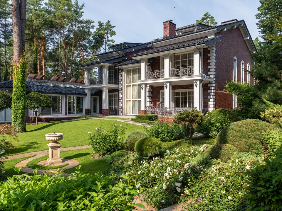 Garteninspiration mit Beeten, Rasen und einer begrünten Hausumgebung.