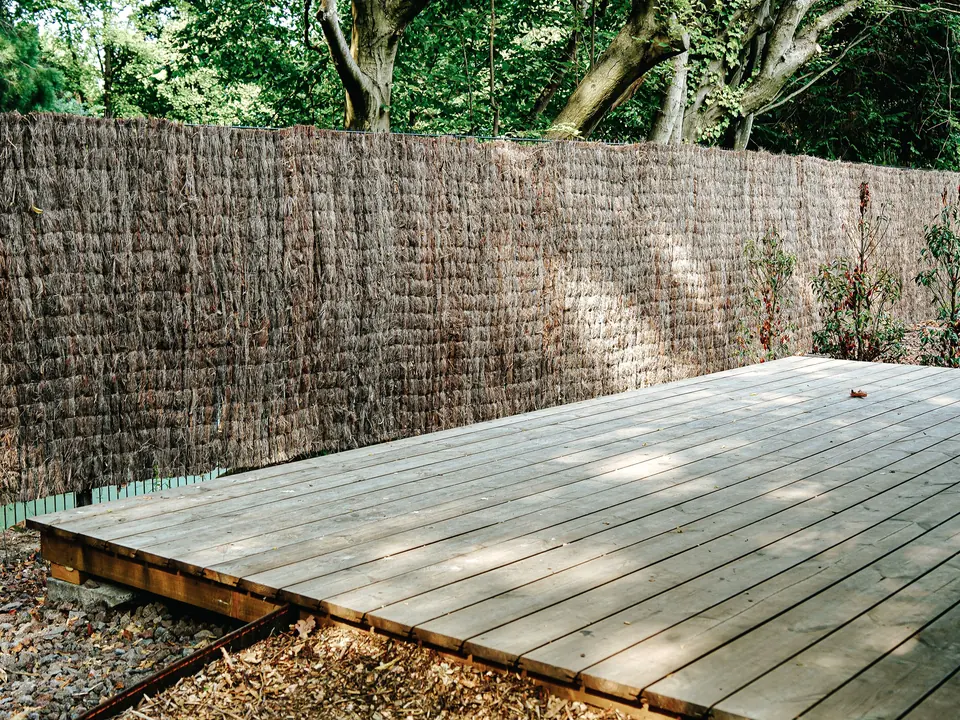 Natürlicher Sichtschutz an einer Holzterrasse im Garten.